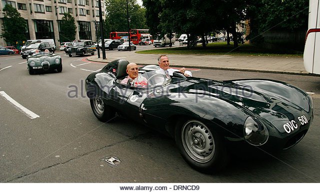 sir-stirling-moss-driving-a-jaguar-xk-around-hyde-park-corner-in-london-drncd9[1].jpg